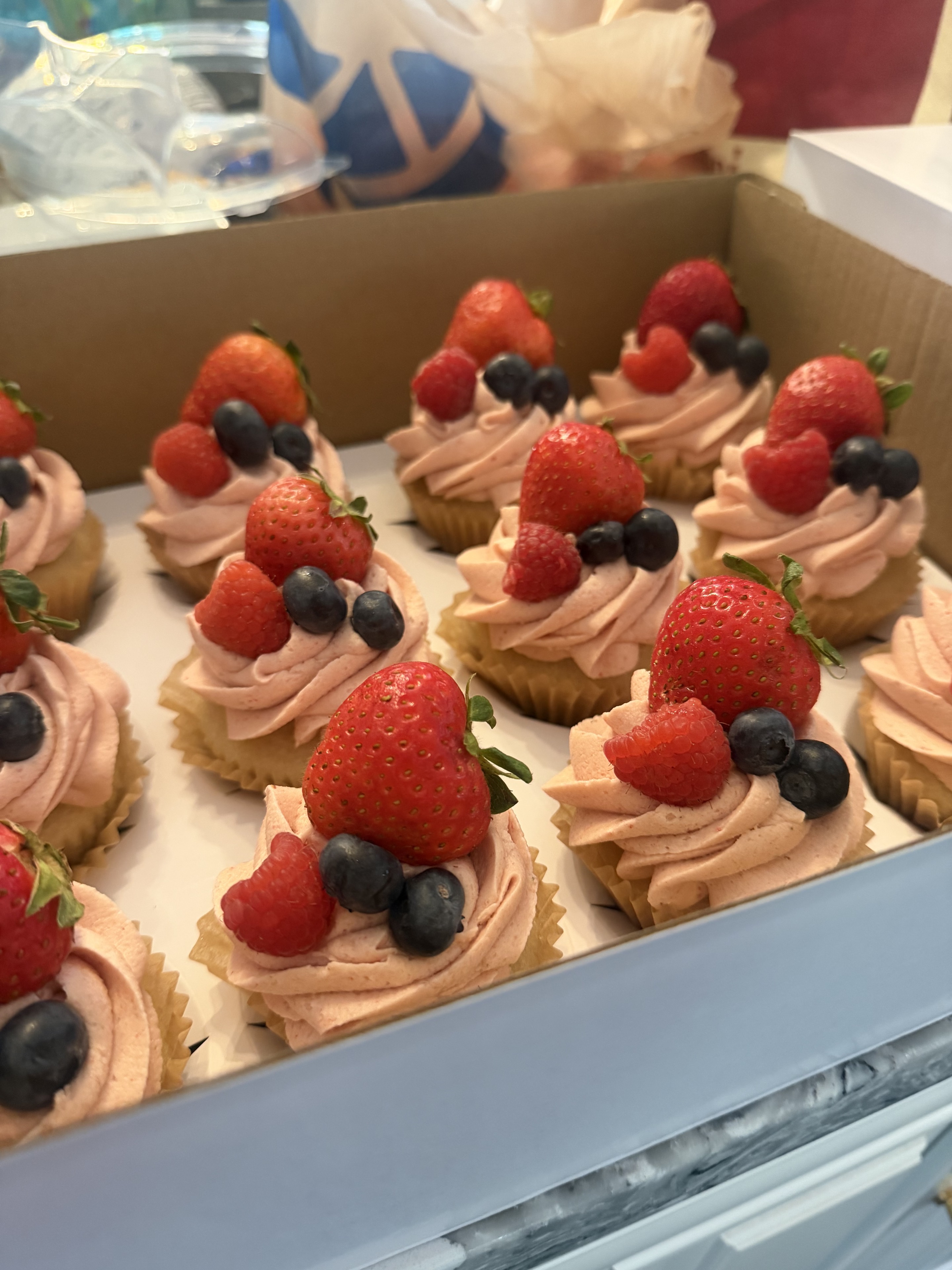 Mixed berry cupcakes topped with strawberries, raspberries, and blueberries